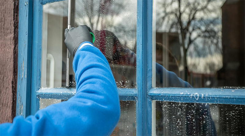 Gebäudereiniger beim Putzen eines Fensters